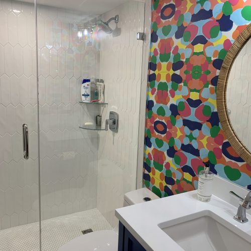 clean tub, bathtub glass, sink, and mirror in colorful bathroom